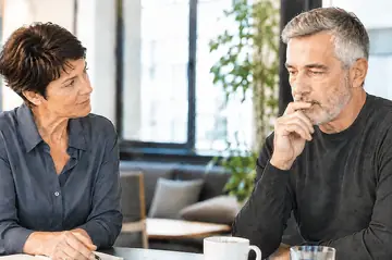 Une femme écoute un homme qui réfléchit pendant une conversation